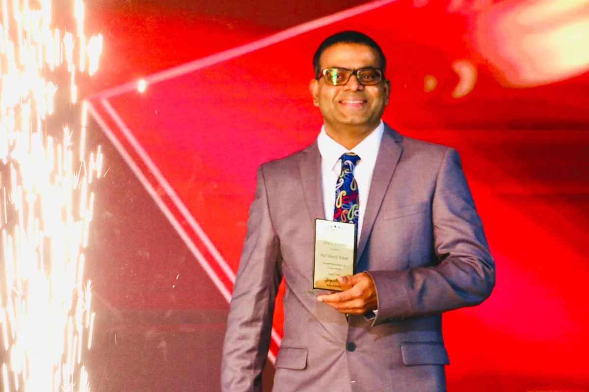 Realtor Sharif Khan holding an award plaque